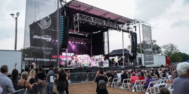 A concert speaker system adorns a stage at a live show