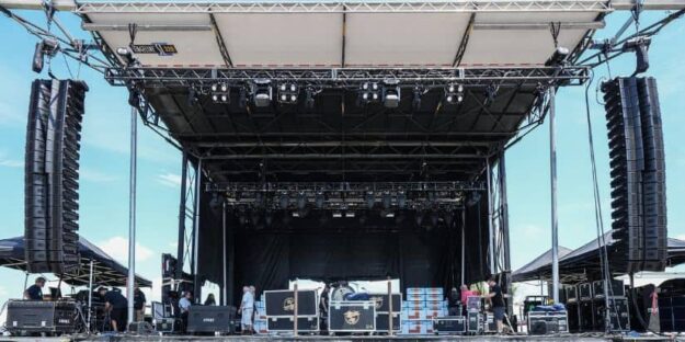 Concert stage rental providers setting up a mobile stage at an event